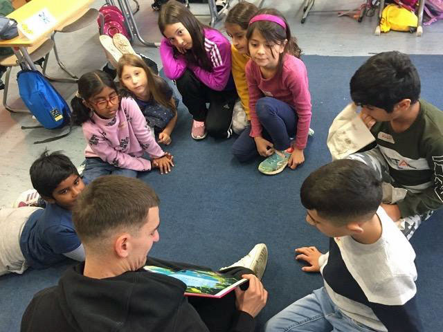 Gruppe von jugendlichen sitzt am Boden im Kreis